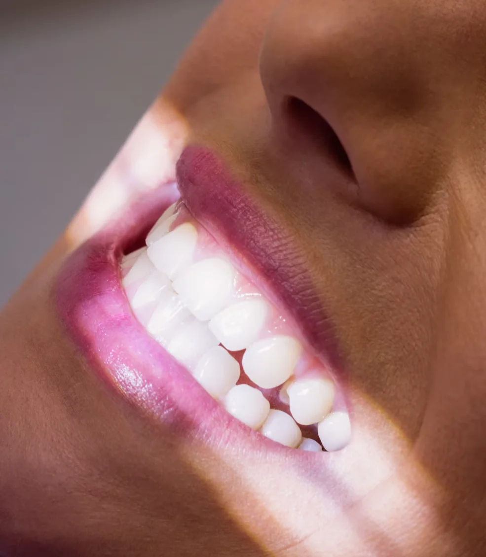 Dental consultation between a woman in scrubs and a man, discussing on a smartphone in a modern office setting.